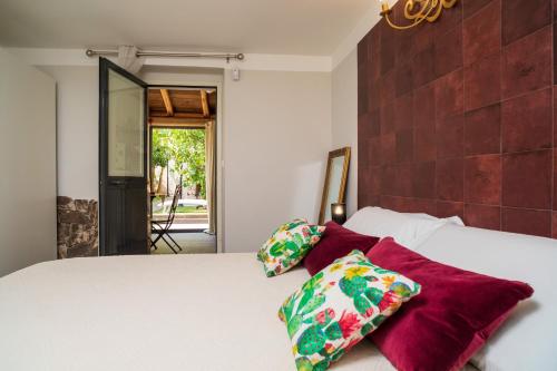 a bedroom with a white bed with two pillows at A Ugghia- Dependance in Fiumefreddo di Sicilia