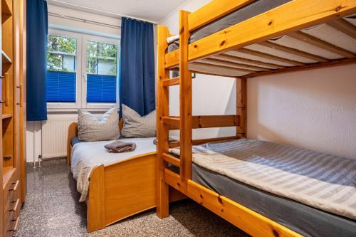 a bunk bed room with two bunk beds and two windows at Haus Hügel - Wohnung 3 in Binz