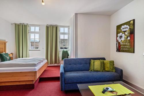 a bedroom with a bed and a blue couch at Landhaus Christophorus in Forbach