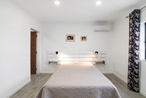 Cette chambre blanche comprend un grand lit. dans l'établissement Apartamento Sunset, à Moncarapacho