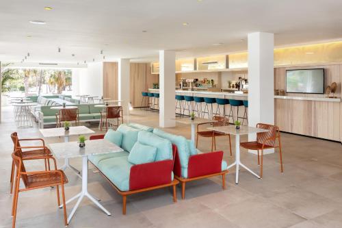 a restaurant with a couch and tables and chairs at Sol Fuerteventura Jandia - All Suites in Morro del Jable