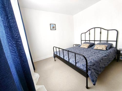 1 dormitorio con cama de metal en una habitación blanca en Le clos de Valletot, en Valletot