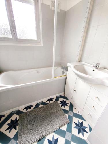 a bathroom with a white tub and a sink at Le Clos de Valletot in Valletot