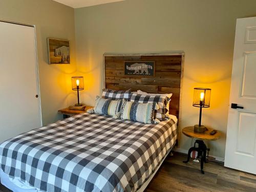 a bedroom with a bed with two lamps on two tables at Loon Mountain Retreat with Pool and Hot Tub in Lincoln