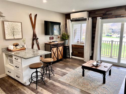 a kitchen with a counter and a table in a room at Loon Mountain Retreat with Pool and Hot Tub in Lincoln