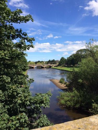 a view of a river with a bridge in the background at Ravelston House in Musselburgh