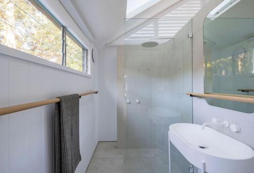 a bathroom with a sink and a glass shower at Crane Lodge in Palm Beach