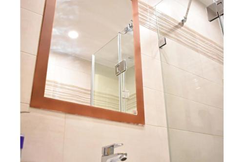 a bathroom with a mirror and a sink at Manolika Studio 6 in Kithnos