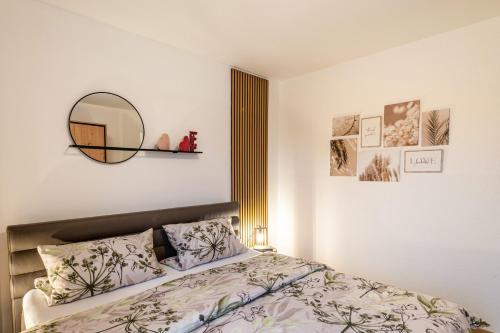 a bedroom with a bed with a mirror on the wall at Domizil Eden - Erdgeschoss in Göhren-Lebbin