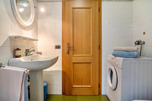 a bathroom with a sink and a washing machine at Casa Magda in Tesero