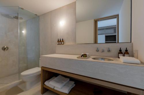 a bathroom with a sink and a toilet and a shower at Capitalia Reforma Chapultepec in Mexico City