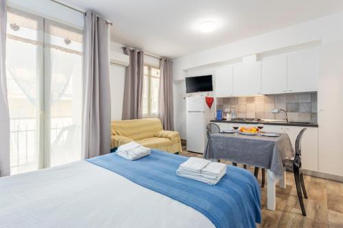 a bedroom with a blue bed and a kitchen at Casavacanzefranca - 14 in Terrasini