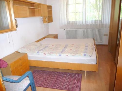 a small bedroom with a bed and a chair at Ferienwohnung Braun in Seelfingen