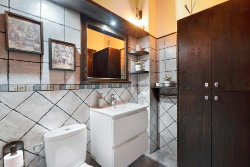 une salle de bain avec toilettes, lavabo et miroir dans l'établissement Ático Miranda, à Icod de los Vinos