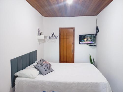 a bedroom with a bed and a tv on the wall at Flat Lua Nova - Pituba I coração da vila e caminho praias in Itacaré