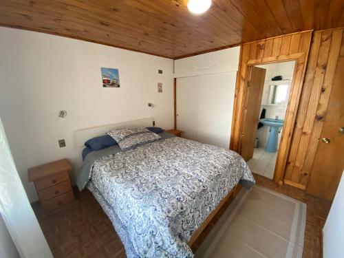 a small bedroom with a bed and a bathroom at Cabaña Vista Mar in Tongoy