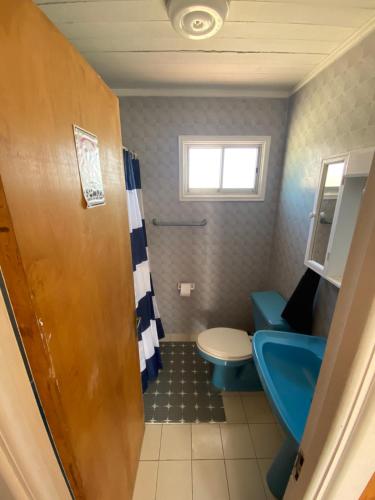 a bathroom with a blue toilet and a sink at Cabaña Vista Mar in Tongoy
