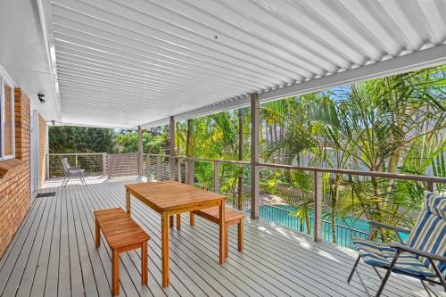 a porch with a wooden table and chairs on a deck at Beachside Bliss Spacious Forster Getaway in Forster
