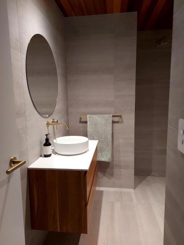 a bathroom with a sink and a mirror at Absolute beachfront in Papamoa in Tauranga