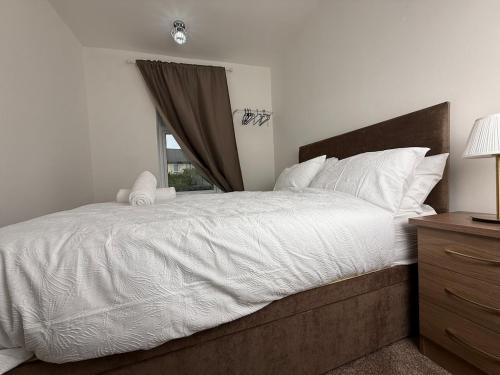 a bedroom with a large white bed with a window at Spacious 3 Bedroom With Garden and Free Parking in Rawmarsh