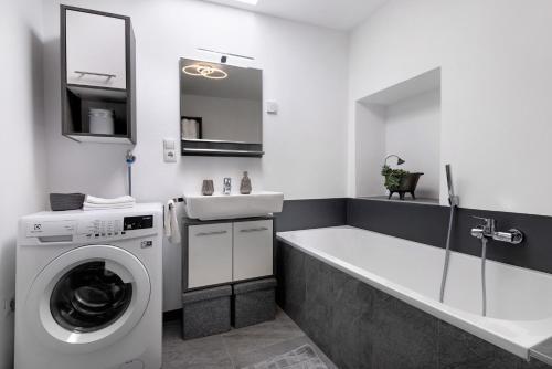 a bathroom with a washing machine and a sink at Ferienwohnung Garboshof in Lasa
