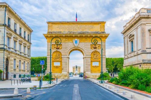 an arch in a street in front of a building at T2 Avec Jacuzzi En Face de l'Arc de Triomphe B in Montpellier