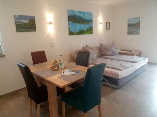 a dining room with a table and a couch at Ferienwohnung Rositta in Bad Endorf