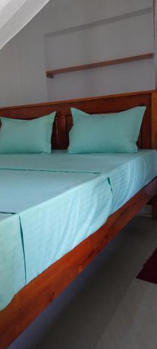 a bed with blue sheets and pillows in a room at Samaya guesthouse in Tangalle