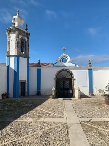 a white and blue building with a clock tower at PENICHE As Estrelas -Trois hébergements au choix accès indépendants même rue - proche centre -calme -confort -climatisés - plages -surf- Parking free in Peniche