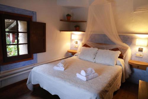 a bedroom with a bed with towels on it at Casa del Pastor-Brugarolas Village in Castelltersol