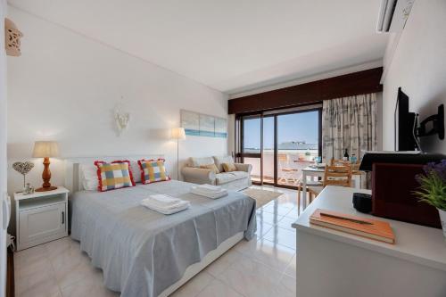 a bedroom with a bed and a living room at Casa Pôr do Sol in Alvor