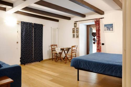 a bedroom with a bed and a dining room at Chalet Provenzale Trilocale in Acceglio