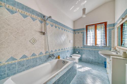 a bathroom with a tub and a sink and a toilet at Villa Del Riccio in Magione