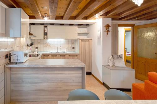 a kitchen with a counter and chairs in a room at Appartamento Zopel in Falcade