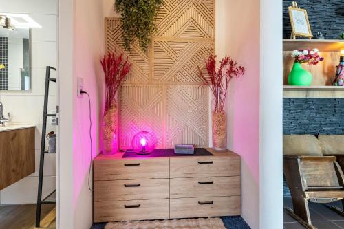 a dresser in a room with a pink wall at Das Atelier in Ihlow