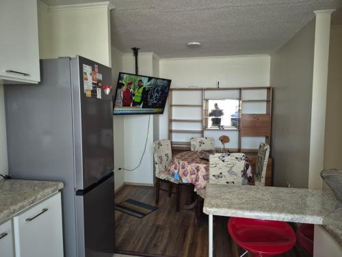 een keuken en eetkamer met een tafel en een koelkast bij Aires in La Serena
