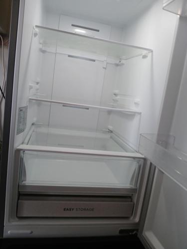 een witte koelkast met open deur en lege planken bij Aires in La Serena