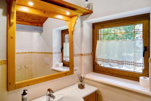 um banheiro com uma pia e um espelho em Appartamento Palmina em Falcade