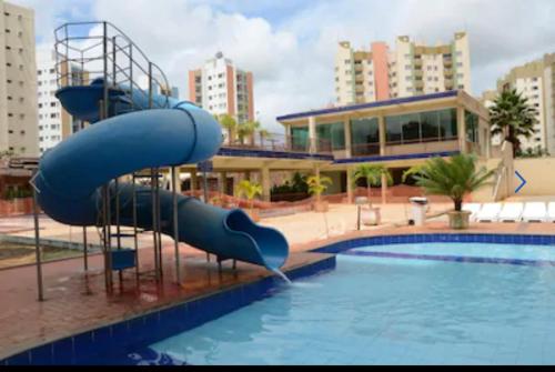 a blue water slide in a swimming pool at Apartamento 3 quarto com ótima área de lazer in Caldas Novas