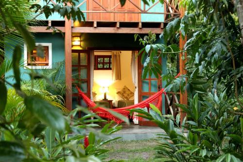 a red hammock in front of a house at Pousada Vila Araticum in Santo André