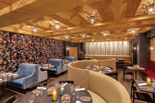 a restaurant with couches and tables and chairs at Morosani Posthotel in Davos