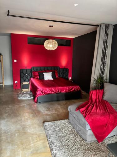 een rode slaapkamer met 2 bedden en een bank bij Love Room L Interlude in Vitrolles