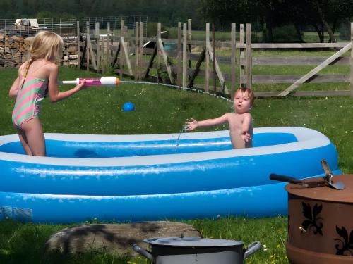 une petite fille et un petit garçon jouant dans une piscine gonflable dans l'établissement Hobbyhof bei Plau am See, à Kressin