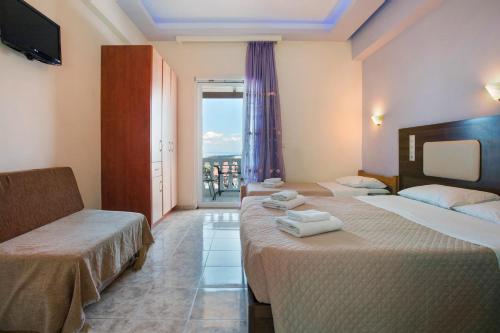 a hotel room with two beds and a balcony at Zante View Family Studio 5 in Tsilivi