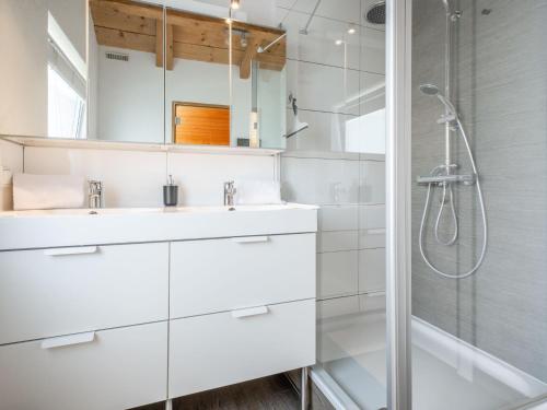 a white bathroom with a shower and a sink at Cervus in Bruck an der Großglocknerstraße