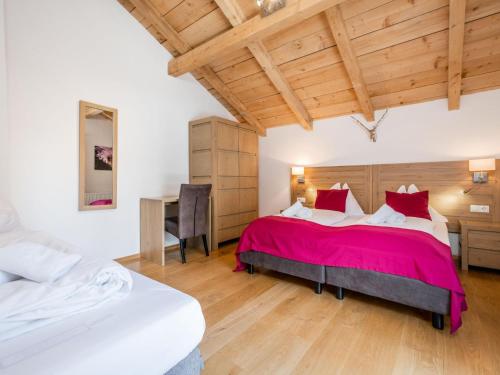 a bedroom with two beds and a desk at Cervus in Bruck an der Großglocknerstraße