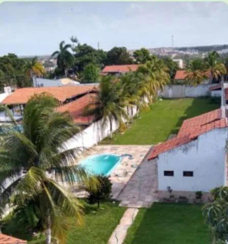 an aerial view of a house with a swimming pool and palm trees at Casa para temporada pertinho do mar in São José de Ribamar