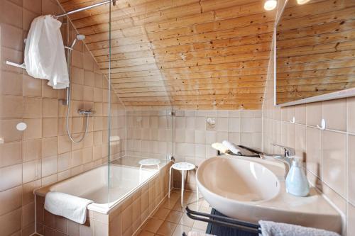 a bathroom with a tub and a sink and a shower at Gästehaus Perlmuschel in Iznang