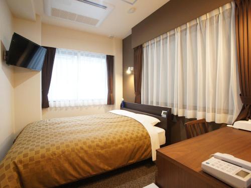 1 dormitorio con cama, escritorio y ventana en Hotel Trend Asakusa, en Tokio