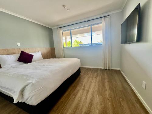 ein Schlafzimmer mit einem großen Bett und einem großen Fenster in der Unterkunft Albany Oak Motel in Auckland